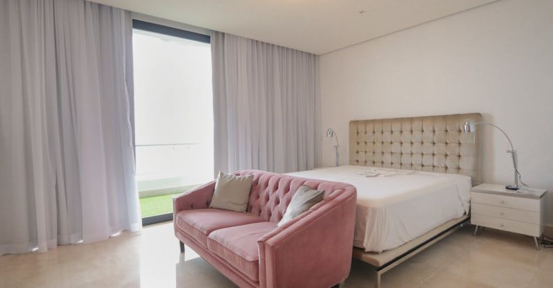 Sofa Bed - A bedroom with pink furniture and a large window